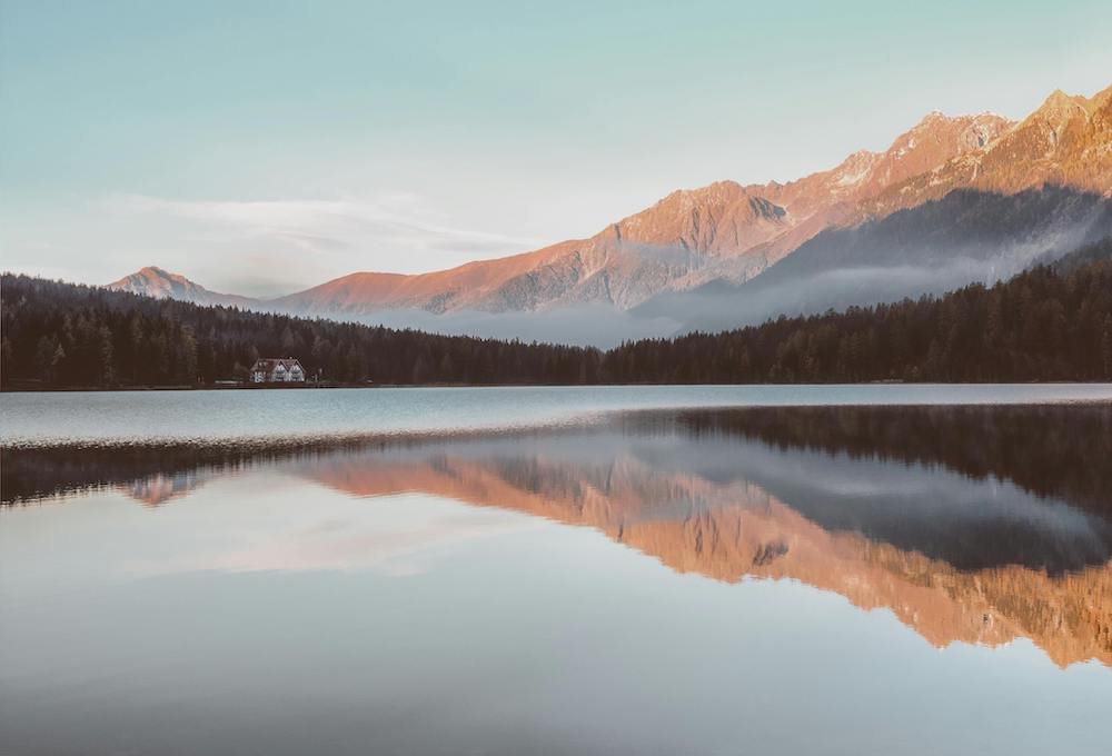 Still lake with mountains in the background in soft light